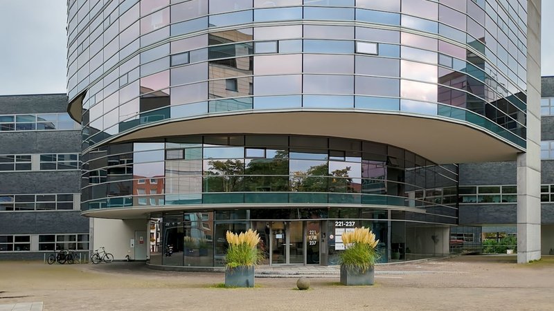 Gebogen glazen gevel met luifel en entree — dagkantoor Avenue Ceramique 221 in Maastricht