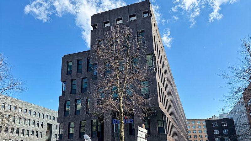 Donkere bakstenen kantoorgevel met Regus-belettering — dagkantoor Randwyck in Maastricht