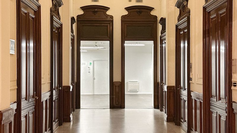 ufficio per 3-6 persone Torino — Corridoio con boiserie in legno scuro e due porte aperte su stanze bianche, Corso Valdocco a Torino